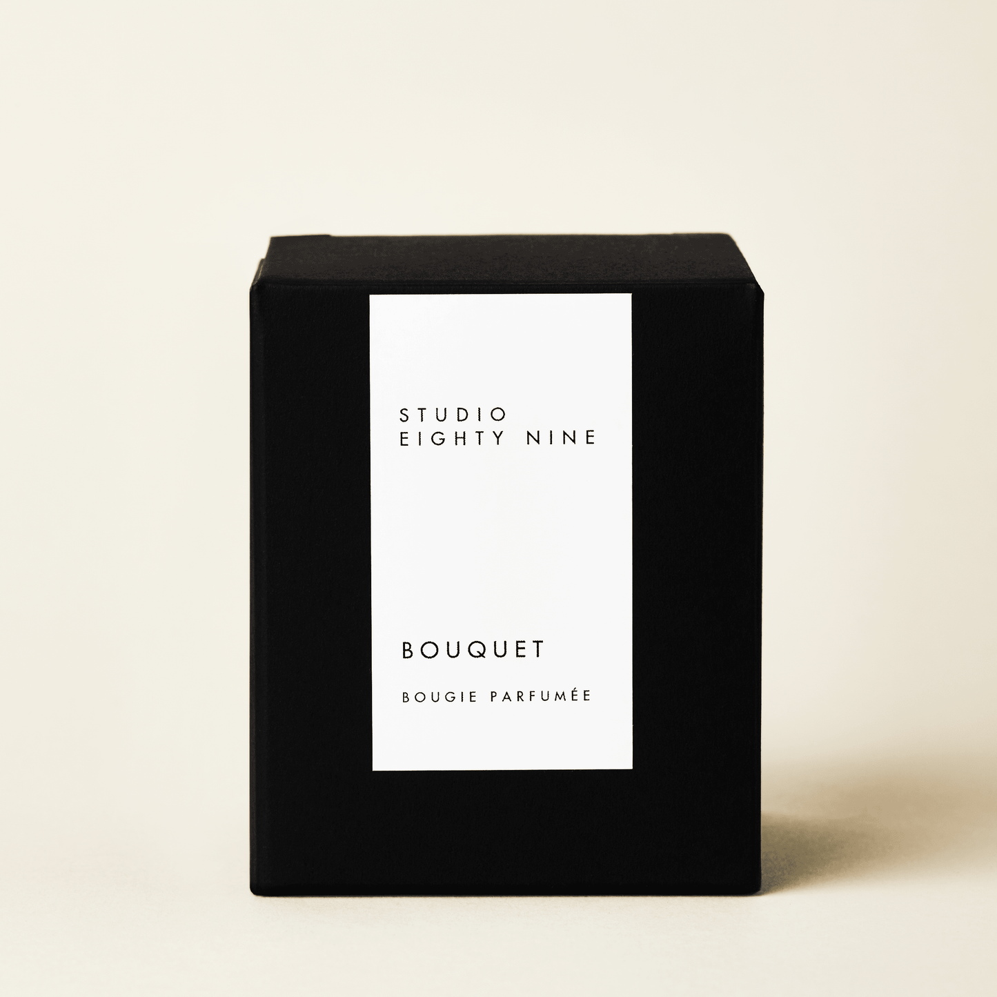 Grande-sized black cubic candle box with a white minimalist rectangular vertical label on the front, featuring the brand "STUDIO EIGHTY NINE", scent "BOUQUET", and product "BOUGIE PARFUMÉE" in clean, uppercase typography.