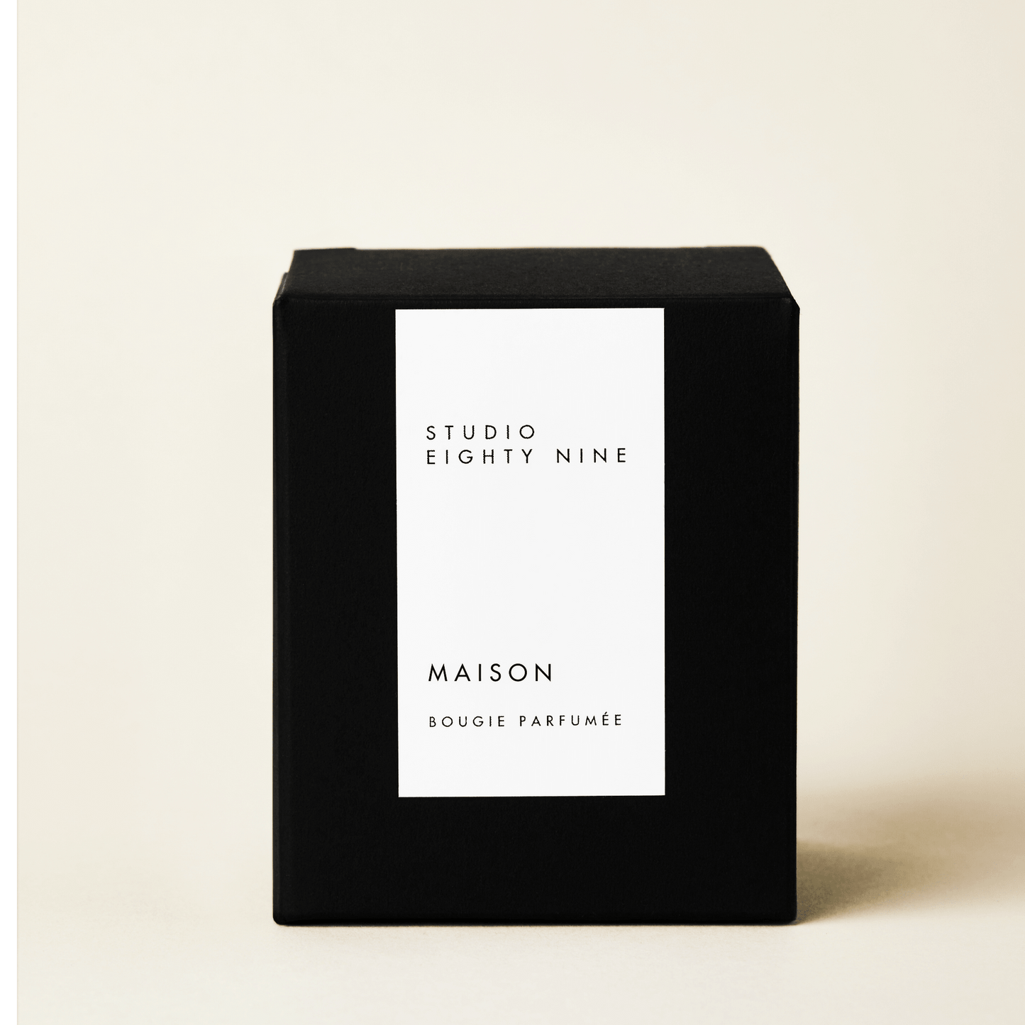 Classic-sized black cubic candle box with a white minimalist rectangular vertical label on the front, featuring the brand "STUDIO EIGHTY NINE", scent "MAISON", and product "BOUGIE PARFUMÉE" in clean, uppercase typography.